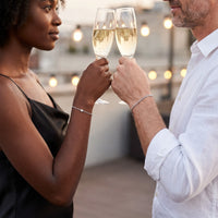 Thumbnail for Heart Bond Matching Bracelet Set in Silver — worn by a couple toasting with champagne