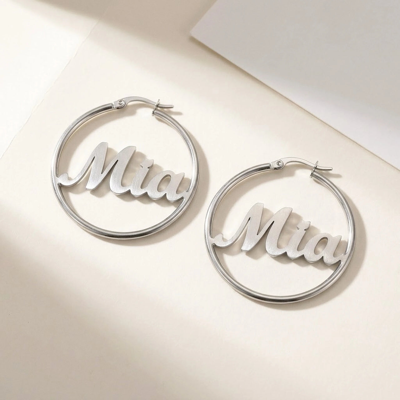 Custom Name Hoop Earrings in Silver, studio packshot of the pair on a plain background | SKU: name-hoop-silver-30-mm