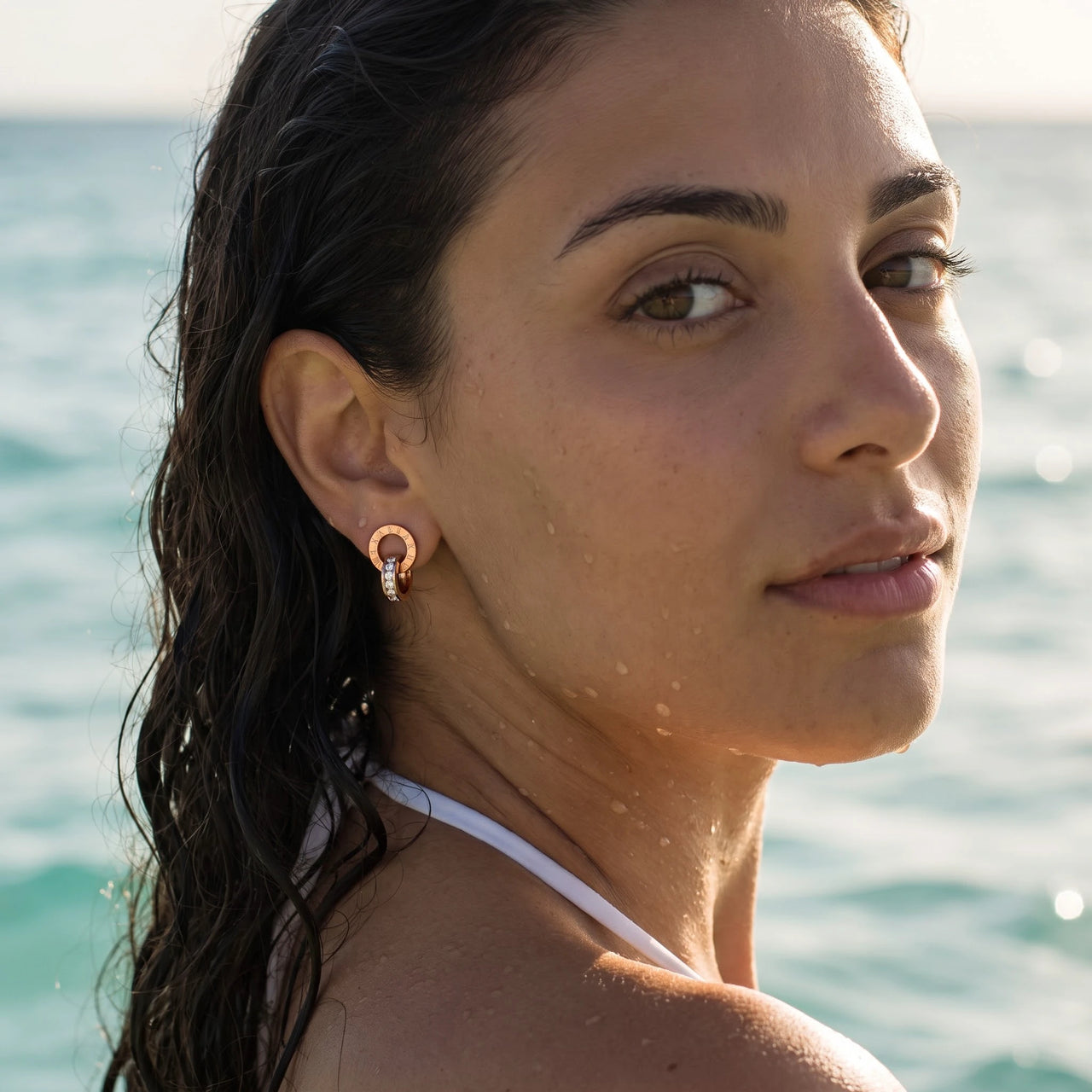 Rose gold huggie hoop earrings worn in the sea, waterproof stainless steel with water drops | SKU: 11137578-rose-gold