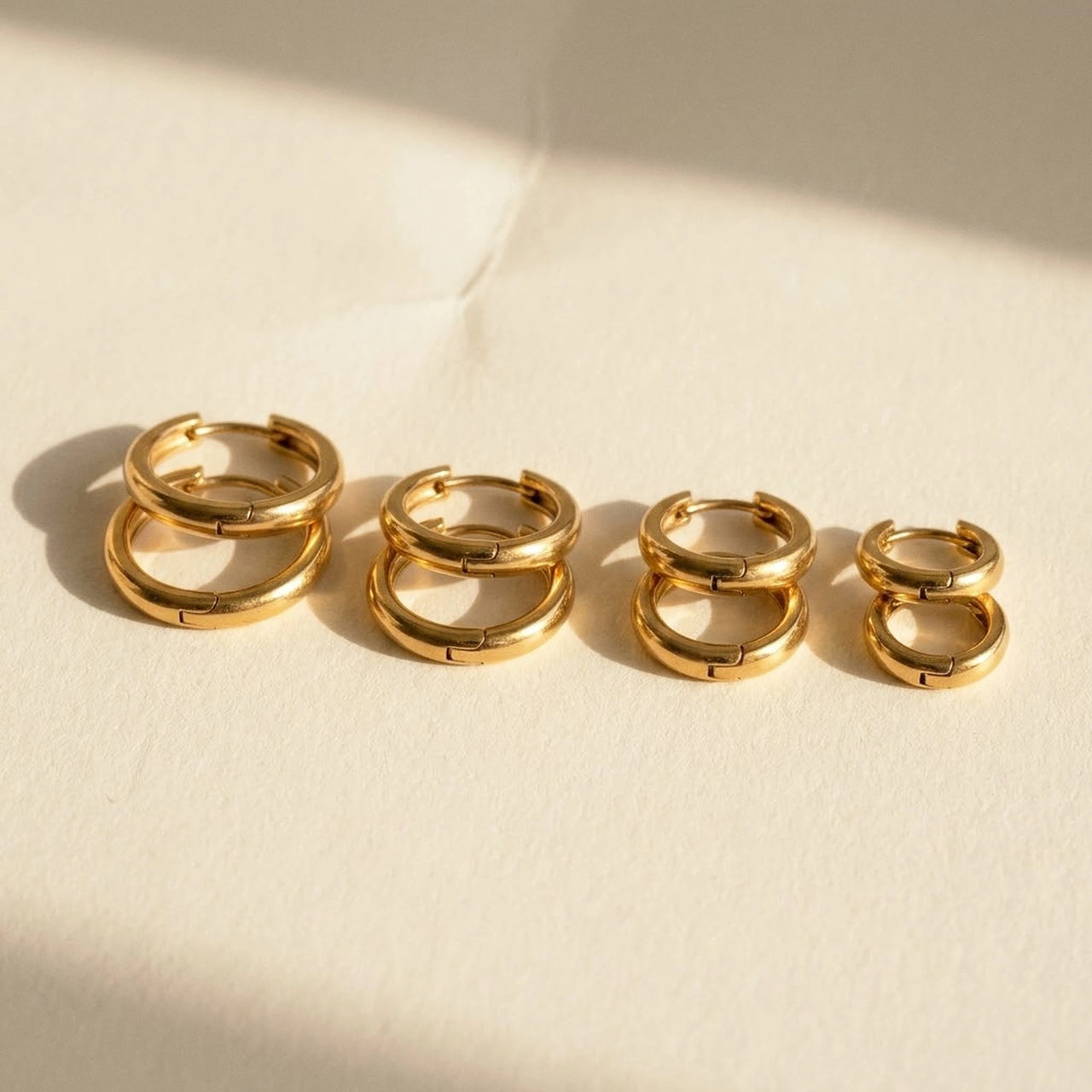 Huggie Hoop Earrings Set of 4 Pairs in Gold, studio packshot of the pair on a plain background | SKU: huggie-set-gold