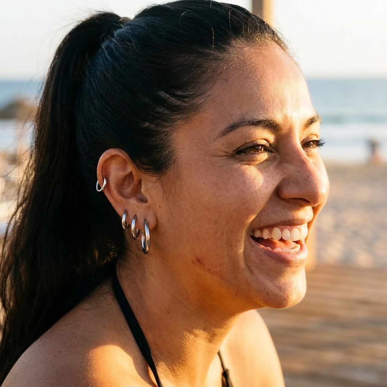 Huggie Hoop Earrings Set of 4 Pairs in Silver worn outdoors, lifestyle shot | SKU: huggie-set-silver