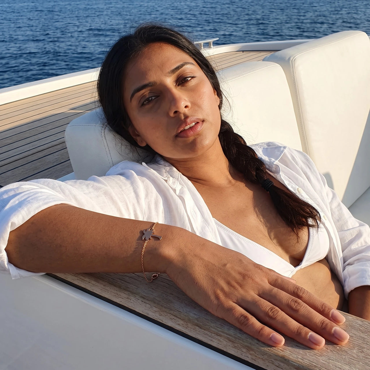 Woman on a yacht wearing the rose gold charm bracelet | SKU: 7819407-rose-gold-color