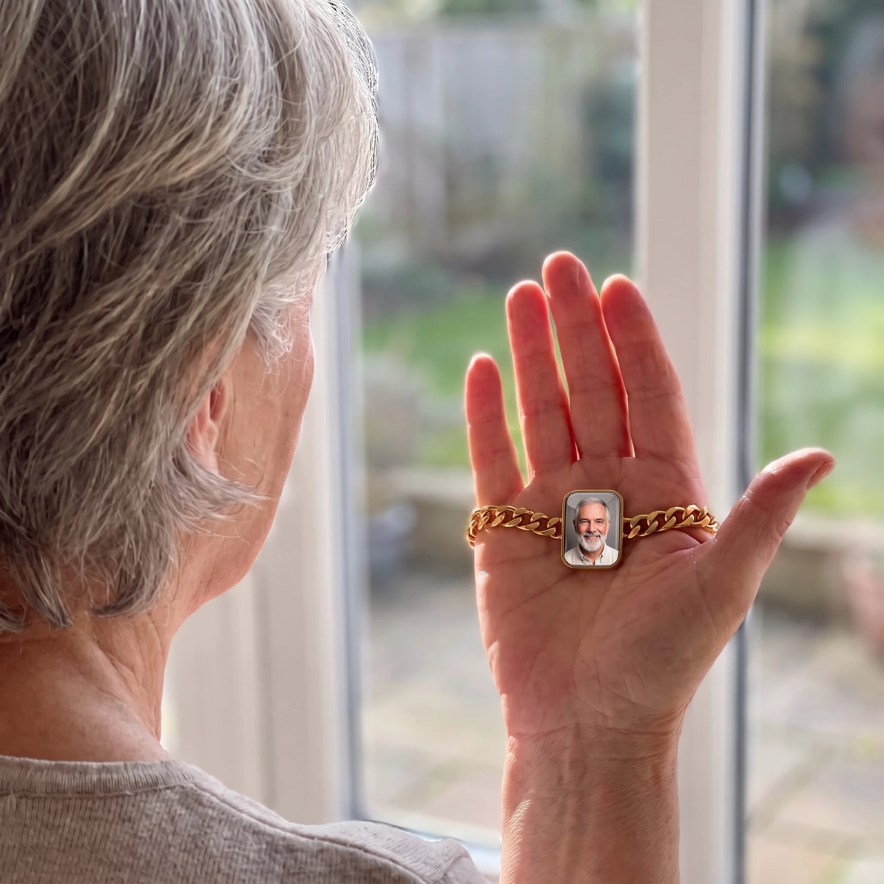 Woman looking at her husband's photo in the gold cushion-cut photo bracelet resting in her palm | SKU: TPH-CUSB-GOLD