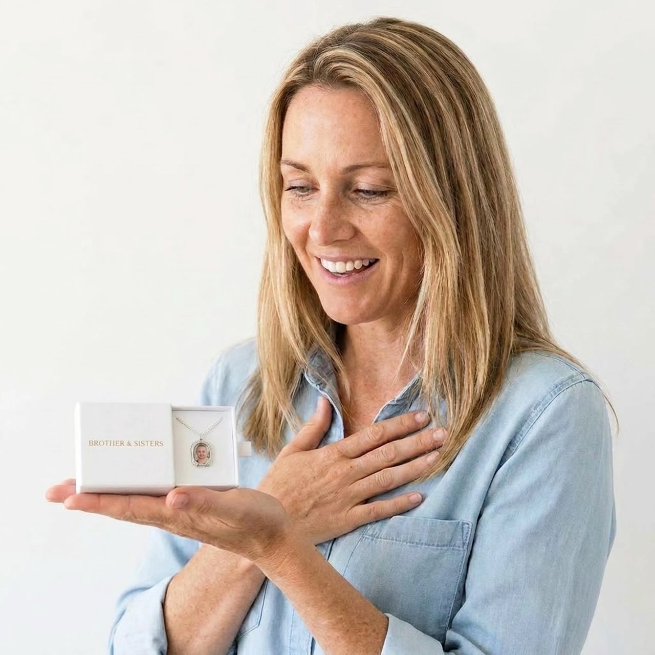 The silver oval photo necklace with a newborn's photo in the Brother & Sisters gift box | SKU: TPH-OVLN-SILVER
