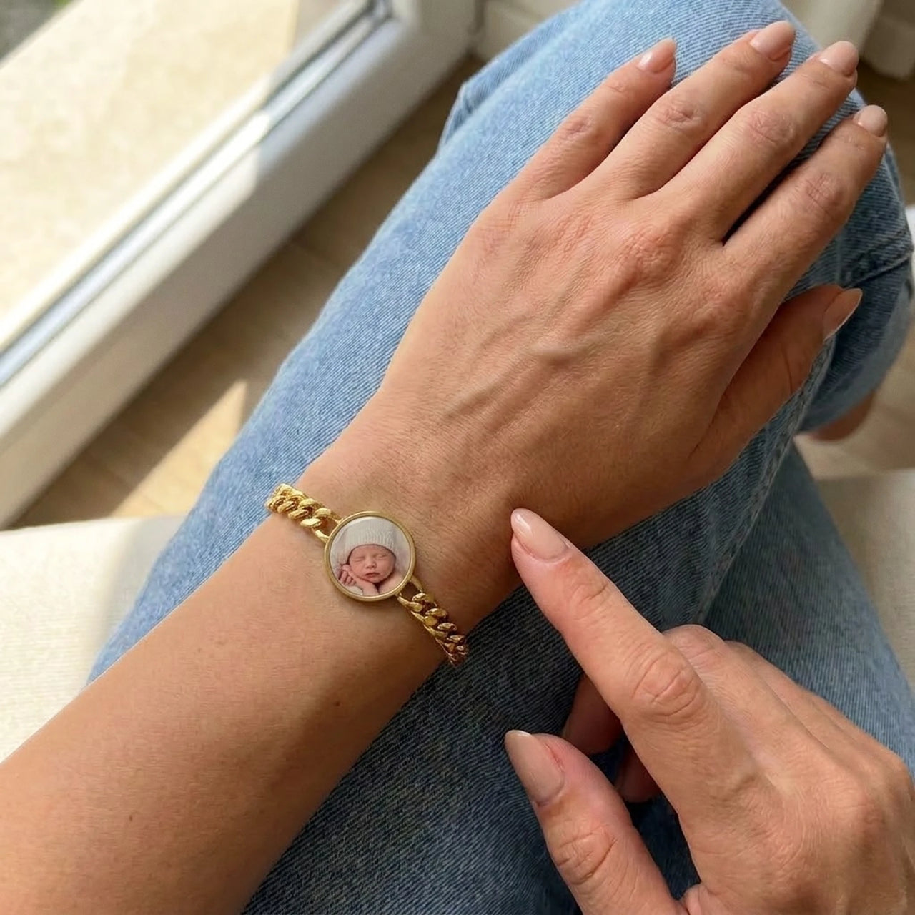 Looking down at the gold round photo bracelet on her wrist, showing its real small size | SKU: TPH-RNDB-GOLD