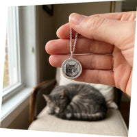 Thumbnail for Customer photo: the silver round necklace with her cat's photo, her cat in the background | SKU: TPH-RNDN-SILVER
