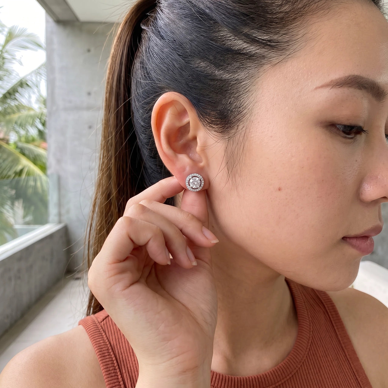 Woman gently touching her silver stud earrings | SKU: 19991927