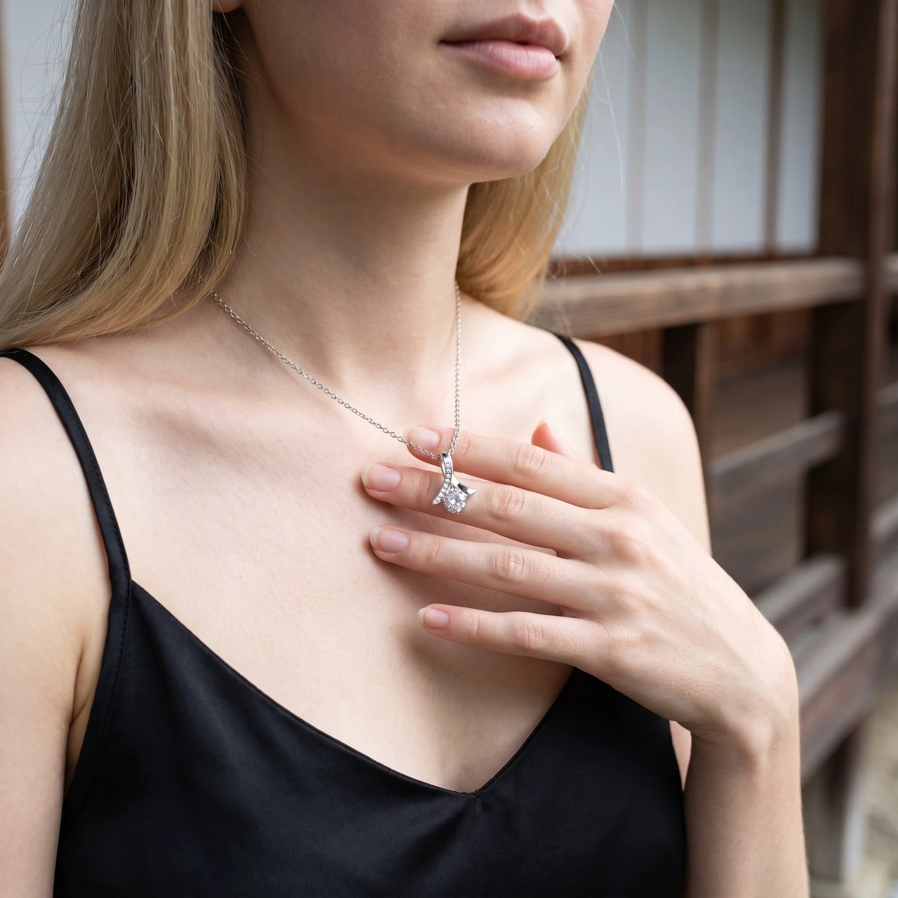 Woman gently touching her silver necklace | SKU: 6309048